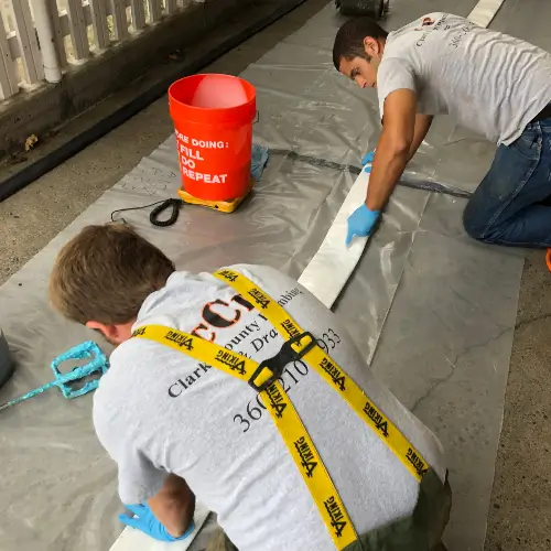 Two Clark County Plumbing technicians preparing a long NuFlow structural lining in Vancouver WA